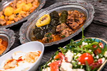 Eid Mubarak Traditional Ramadan Iftar dinner. Assorted tasty food in authentic rustic dishes on wooden blue background. Turkish Bosnian food meat kebab, pita, Sarma, klepe, sogan dolma.