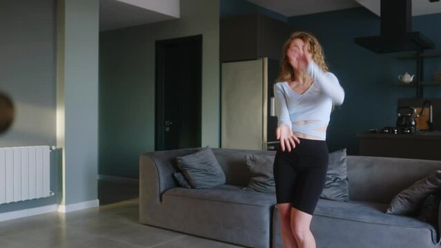 Teen girl recording video of trendy dance challenge for likes and followers on social media platform. Woman funny dancing, filming her performance for stories on camera in living room at home studio.