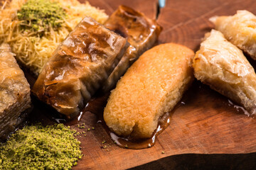 Ramadan Kareem, traditional Turkish middle eastern Iftar sweets Baklava with pistachios and fresh honey on rustic wooden plate and vintage blue background table. Top view.