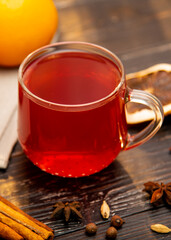 A mug of fruity red tea on a wooden background.