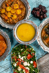 Eid Mubarak Traditional Ramadan Iftar dinner. Assorted tasty food in authentic rustic dishes on wooden blue background. Turkish Bosnian food meat kebab, pita, Sarma, klepe, sogan dolma.