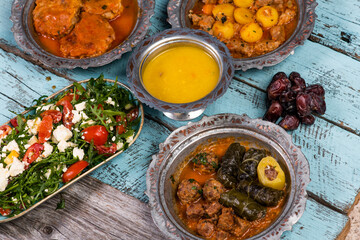 Eid Mubarak Traditional Ramadan Iftar dinner. Assorted tasty food in authentic rustic dishes on wooden blue background. Turkish Bosnian food meat kebab, pita, Sarma, klepe, sogan dolma.