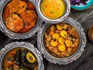 Eid Mubarak Traditional Ramadan Iftar dinner. Assorted tasty food in authentic rustic dishes on wooden blue background. Turkish Bosnian food meat kebab, pita, Sarma, klepe, sogan dolma.