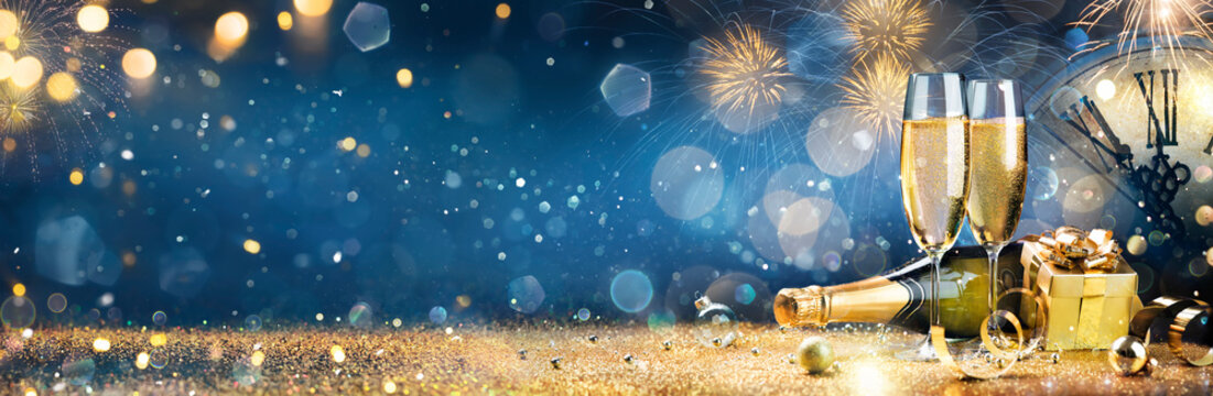 New Year Celebration - Toast With Champagne And Fireworks - Defocused Bokeh Lights And Glittering Effect On Background 