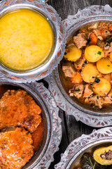 Eid Mubarak Traditional Ramadan Iftar dinner. Assorted tasty food in authentic rustic dishes on wooden blue background. Turkish Bosnian food meat kebab, pita, Sarma, klepe, sogan dolma.