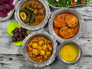 Eid Mubarak Traditional Ramadan Iftar dinner. Assorted tasty food in authentic rustic dishes on wooden blue background. Turkish Bosnian food meat kebab, pita, Sarma, klepe, sogan dolma.