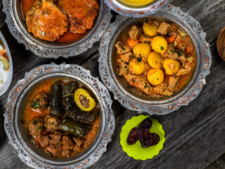 Eid Mubarak Traditional Ramadan Iftar dinner. Assorted tasty food in authentic rustic dishes on wooden blue background. Turkish Bosnian food meat kebab, pita, Sarma, klepe, sogan dolma.