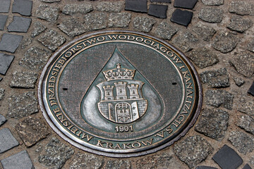 Decorative manhole cover with coat of arms in Jasna Gora, Czestochowa, Poland