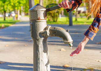 Female pumping water with a hand pump