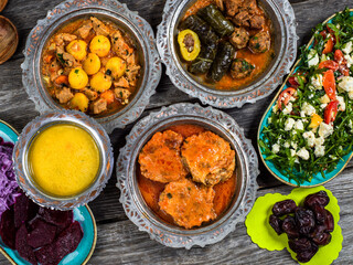 Eid Mubarak Traditional Ramadan Iftar dinner. Assorted tasty food in authentic rustic dishes on wooden blue background. Turkish Bosnian food meat kebab, pita, Sarma, klepe, sogan dolma.