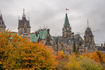 Fototapeta na wymiar Towers of the East Block on Canada's Parliament Hill seen rising in the distance above trees on the Rideau Canal.