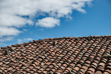 Roof of old country house from weathered aged clay tiles closeup