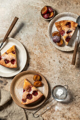 Pieces of The New York Times Plum Cake pie with powdered sugar on brown textured background, top view