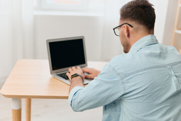 Closeup shot of hands of serious focused handsome businessman work online typing documents using laptop in home office interior. Copy space. Distance remote work communication. Gadget addiction