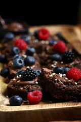 Macro. Brownie cakes with berries and chocolate on top. Delicious chocolate dessert.