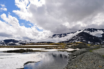 Sognefjell, Jotunheim, Norway - rocky landscape with snow in a natural park. Snow-covered rocks, mountains and icy lakes.