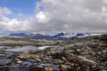 Fototapeta na wymiar Sognefjell, Jotunheim, Norway - rocky landscape with snow in a natural park. Snow-covered rocks, mountains and icy lakes.