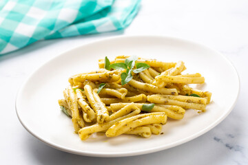 Casarecce pasta with cilantro pesto sauce on a grey background, top view. Delicious vegetarian lunch.