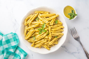 Casarecce pasta with cilantro pesto sauce on a grey background, top view. Delicious vegetarian lunch.
