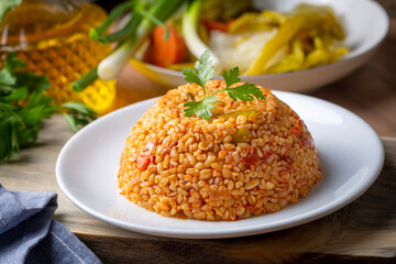 Traditional turkish bulgur pilaf with tomato sause in plate (Turkish name; meyhane pilavi)