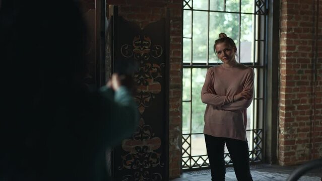 4k Young woman aims at another female and stands in room spbd. Killing eve concept.Asian woman is holding gun in hand and aiming at person, showing confusion and standing in retro interior. Two