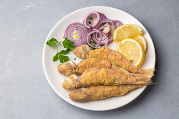 Plate of fried small fish red mullet and lemon