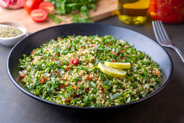 Traditional Lebanese salad tabouli tabule with quinoa, herbs, tomatoes, mint and lemon.