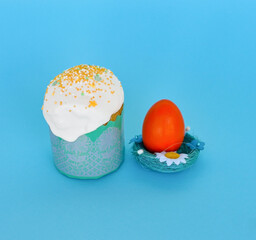 Happy Easter Colorful eggs with cherry blossoms and cake lay on blue background. Spring greeting card