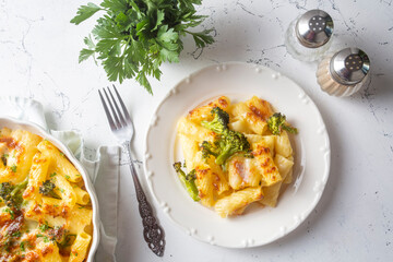 Pasta baked with broccoli and chicken. Broccoli, cheese and gratin sauce on baked penne pasta.