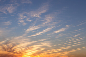 Sunrise, sunset yellow orange blue sky with sun, clouds in sunlight background texture
