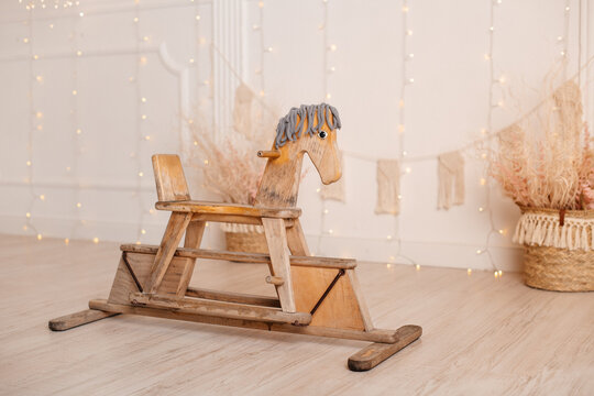 Nice vintage classic wooden rocking horse chair on wooden floor shot in a blurred vintage interior background.