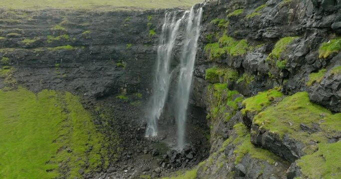 Aerial Forward Shot Of Birds Flying By Waterfall On Island - Faroe Islands, Denmark
