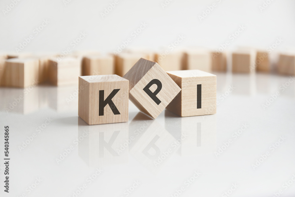 Poster text kpi on wooden blocks with letters on a white background. reflection of the caption on the mirro