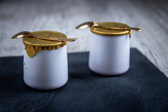 Yaourts natures dans pots blancs avec sucre en poudre