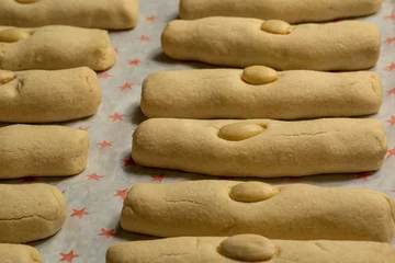 Raamstickers Closeup shot of freshly cooked long cookies with almonds on top on a baking sheet © Luis Alfredo Gonzalez Calkech/Wirestock Creators