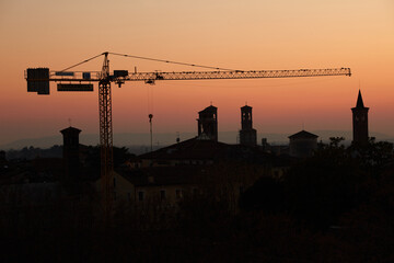 Tower crane at sunset in Bassano del Grappa - obrazy, fototapety, plakaty