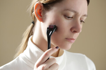 Facial massage with microneedle dermaroller for the treatment of scars, wrinkles and for facial...