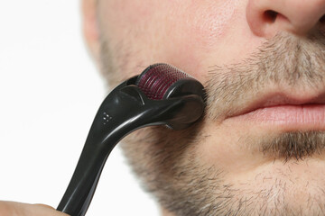 Facial massage with microneedle dermaroller for the treatment of scars, wrinkles and for beard...