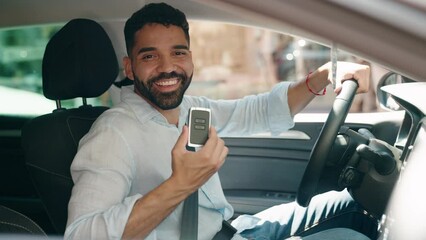 Young arab man smiling confident holding key of new car at street