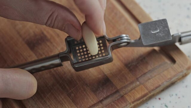 Falling pressed garlic from a metal press, close up