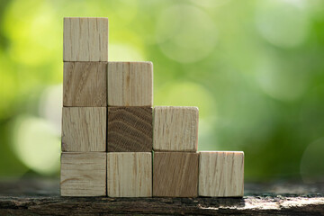 Wooden cubes graph on bokeh nature background.