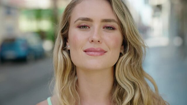 Young blonde woman smiling confident standing at street