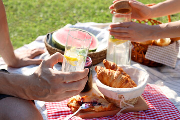 Lovely couple having picnic on sunny day in garden, closeup
