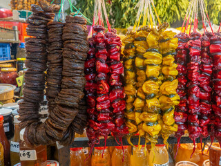 Georgian sweets on the counter. Bundles of figs. Nuts in frozen grape juice on the counter. Plum churchkhela at the market. Sweet food in assortment. Store in Georgia. East market.