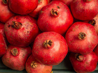 Pomegranates on the counter. Red ripe fruits.  Background from whole pomegranates.