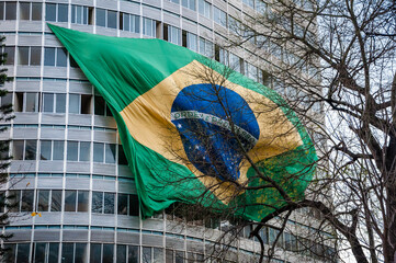 a bandeira do Brasil tremulando do alto de um prédio - obrazy, fototapety, plakaty