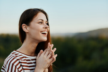 Fototapeta premium Young woman in a striped t-shirt smiles cutely on a journey against the backdrop of autumn nature