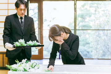 お葬式の納棺で花入れの儀をする日本人女性（号泣）
