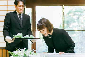 お葬式の納棺で花入れの儀をする日本人女性（お声掛け）
