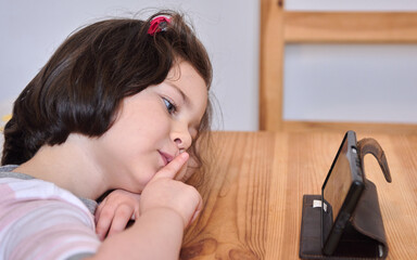 cute girl having a video chat with grandma over the phone